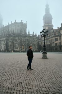 Mann vor Kirche in Dresden bei schlechtem Wetter